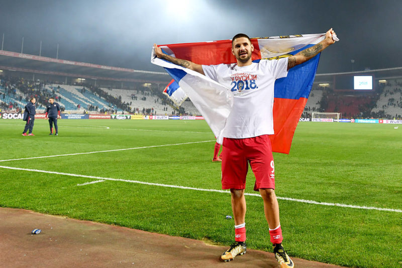 Der serbische Nationalspieler Aleksandar Mitrovic posiert mit der serbischen Flagge, während er den Sieg im Qualifikationsspiel zur FIFA Fussball-Weltmeisterschaft 2018 zwischen Serbien und Georgien im Rajko Mitic Stadion in Belgrad am 9. Oktober 2017 feiert. / AFP PHOTO / ANDREJ ISAKOVIC